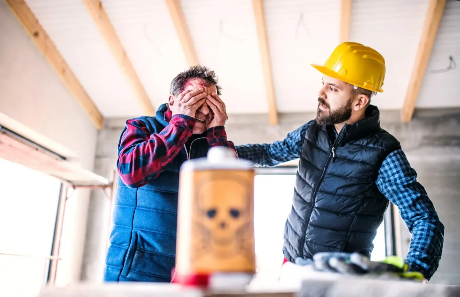 Worker covering face near hazardous materials, highlighting cases involving a chemical burn injury attorney or environmental exposure lawyer in California.