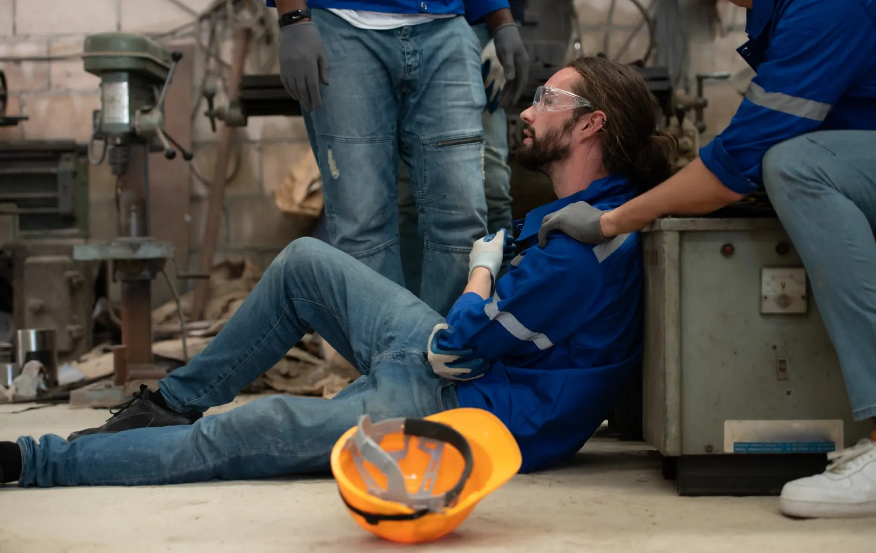 Injured industrial worker receiving help on factory floor, highlighting serious job injury cases handled by workers compensation lawyers in California.
