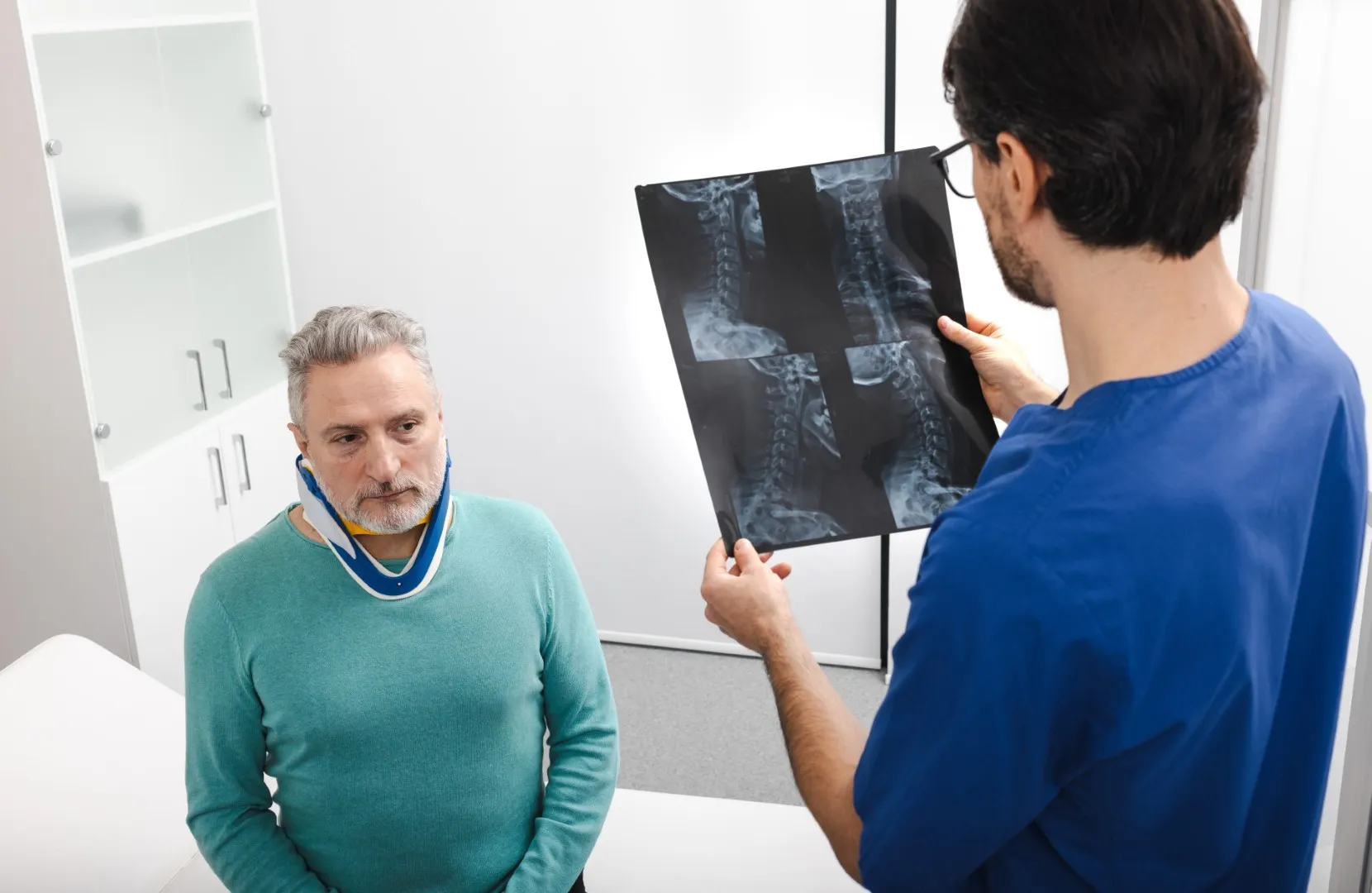 A healthcare professional assessing an X-ray of a worker injured on the job, highlighting the need for legal support in medical claims.