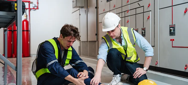 Injured employee receiving assistance in industrial facility, highlighting common factory and industrial injuries under workers compensation law.
