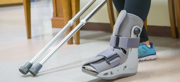 Worker wearing orthopedic boot with crutches after injury, representing workplace accidents handled by workers compensation lawyer Los Angeles.