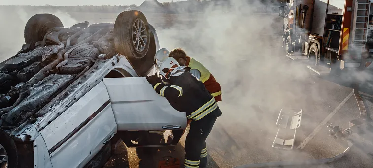 Emergency responders rescuing accident victim from overturned vehicle highlighting cases handled by catastrophic injury attorney California.