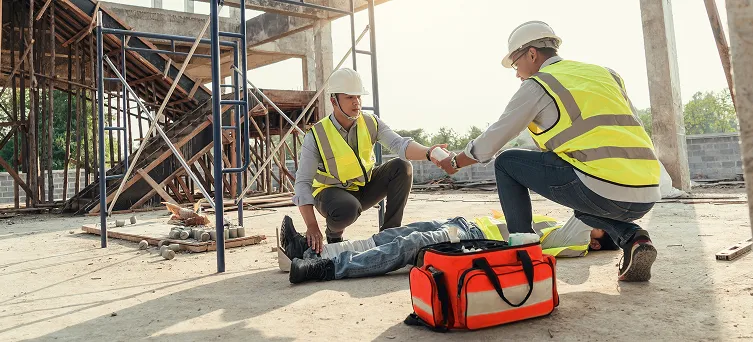 Construction workers helping an injured employee after a jobsite accident, showing immediate steps after a construction injury in California.