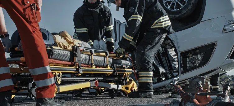 Emergency responders assisting accident victim from overturned vehicle representing catastrophic injury attorney and personal injury lawyer Los Angeles cases.