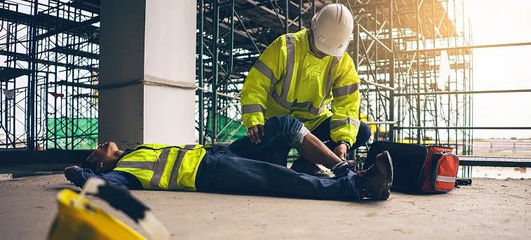 Injured construction worker receiving jobsite aid, highlighting rights under California workers compensation law after a serious workplace accident.