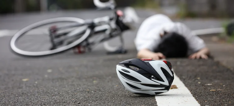 Injured cyclist lying on road beside bicycle after crash highlighting cases handled by bicycle accident lawyer Los Angeles and personal injury attorney.
