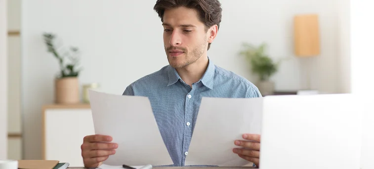 Individual reviewing insurance or compensation documents related to workplace injury settlement handled by workers compensation attorney Los Angeles.