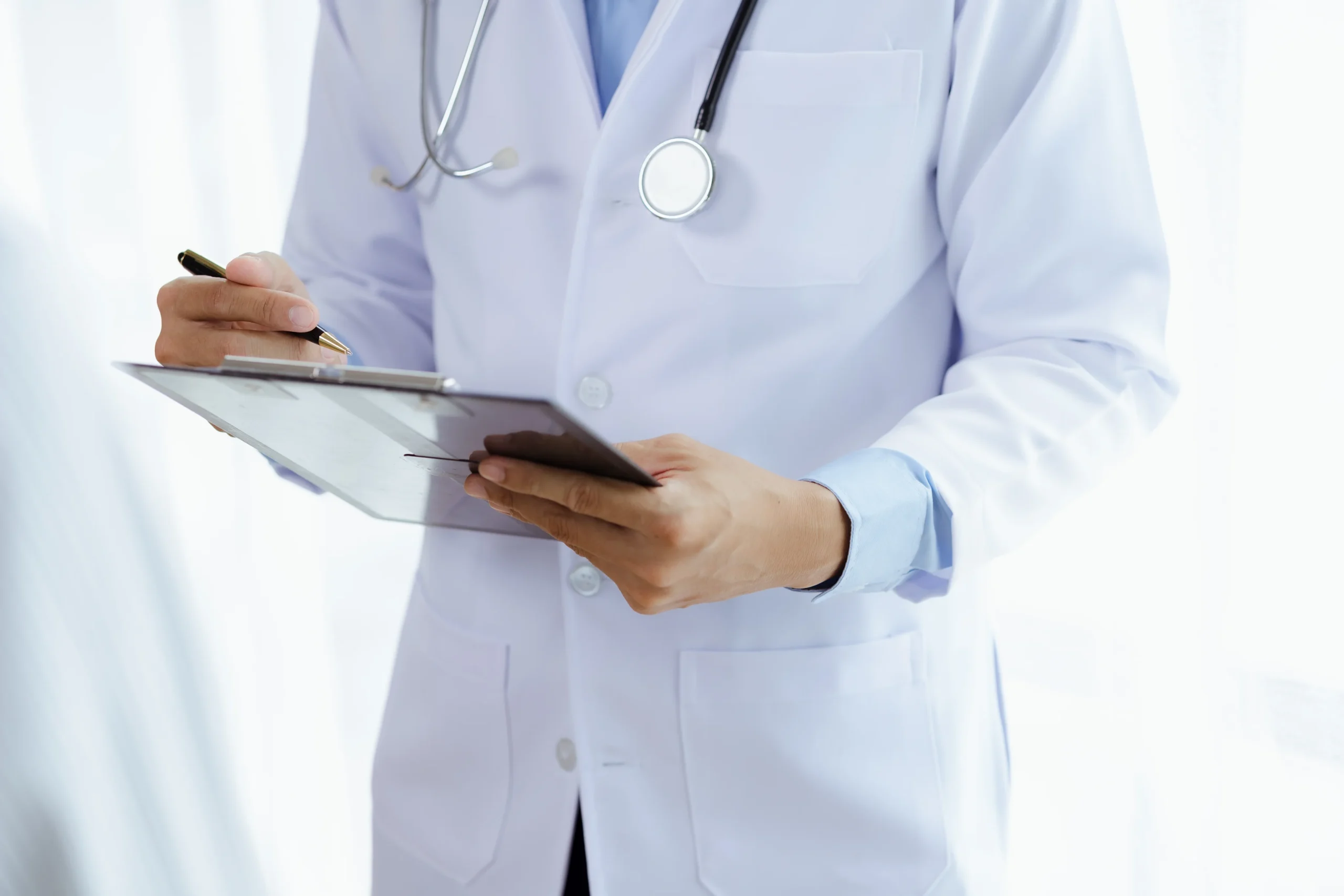 Doctor holding clipboard during workers compensation evaluation, representing medical documentation used in California workplace injury claims.
