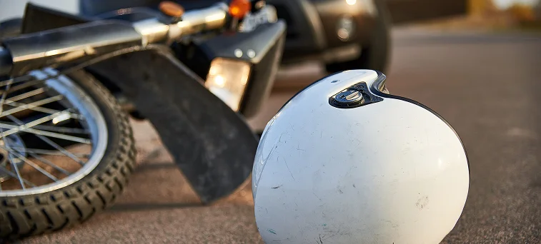 Motorcycle crash scene with helmet on road highlighting accident injury claims handled by motorcycle accident lawyer Los Angeles and personal injury attorney.