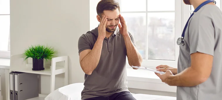Injured worker speaking with doctor about head pain, representing workers compensation claims handled by attorney in California.